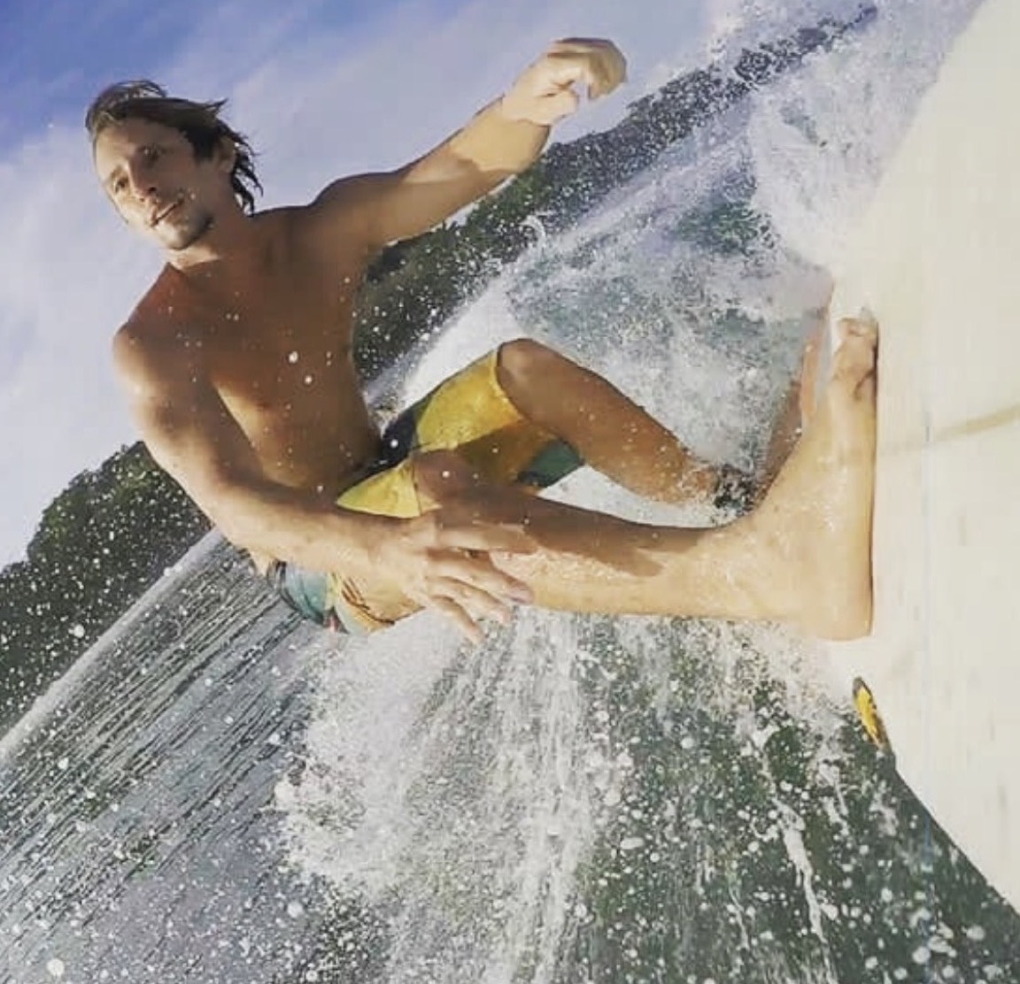 Paulo Cavalcante mid-turn, smiling through the spray